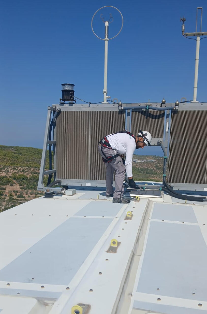 Technician working on top of a wind turbine nacelle